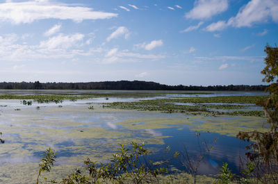 Scenic view of calm lake against cloudy sky