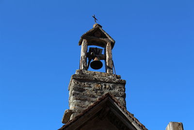 Low angle view of bell tower against blue sky