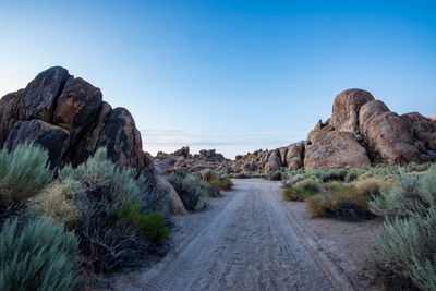 Road amidst rocks against clear sky