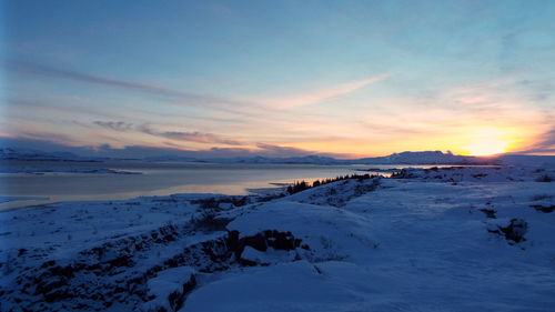 Scenic view of frozen sea against sky during sunset