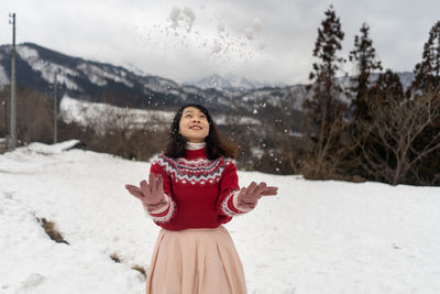 Smiling woman playing with snow