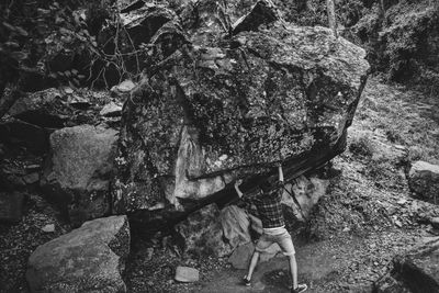 Optical illusion of man pushing boulder rock