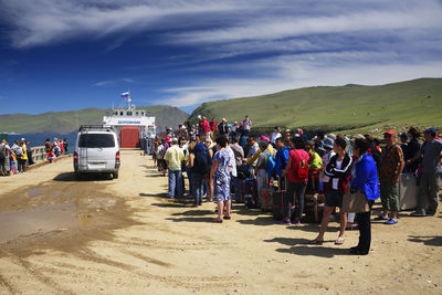 Group of people on road against sky