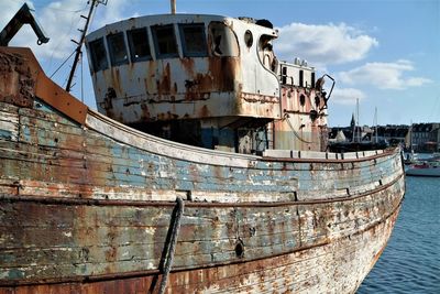 Abandoned ship moored on sea against sky