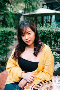 Portrait of young woman sitting outdoors