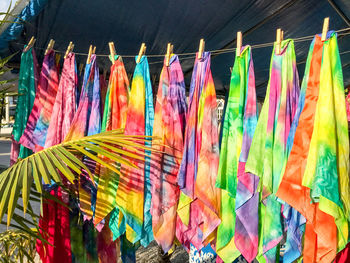 Colorful clothes hanging for sale at market stall