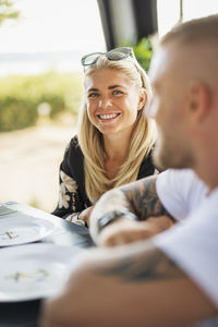 Smiling woman having meal at camping