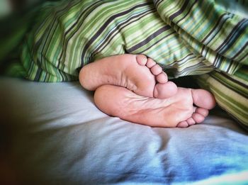 Close-up of woman feet on bed