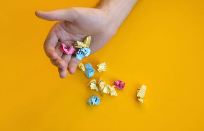 Cropped hand of woman holding pills against blue background