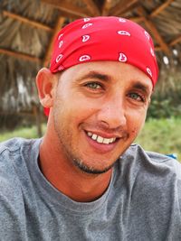 Close-up portrait of smiling man sitting outdoors