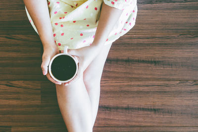 High angle view of woman holding coffee cup
