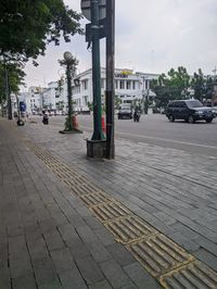 Cars on street in city against sky