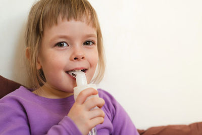  portrait of a smiling child with a nebulizer in his hand. 