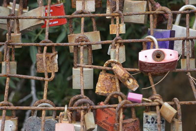 Close-up of rusty padlocks hanging on metal fence