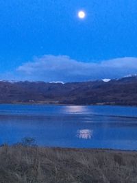 Scenic view of blue sea against sky at night