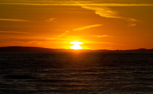 Scenic view of sea against romantic sky at sunset