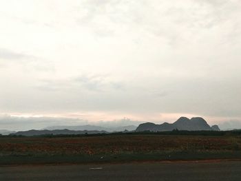 Countryside landscape against cloudy sky