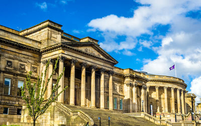 Low angle view of historical building against cloudy sky