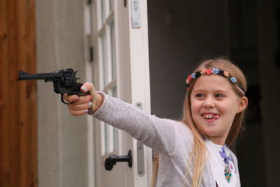 Smiling girl playing with gun