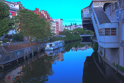 Canal amidst buildings in city against sky