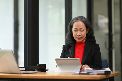 Portrait of young woman using laptop at home