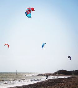 Kite flying over beach against sky