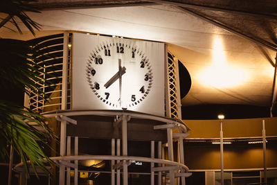 Low angle view of illuminated clock on table