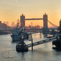 View of suspension bridge in city at sunset