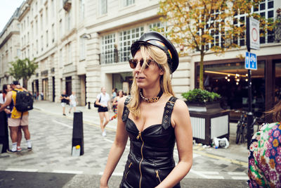 Young woman wearing sunglasses standing in city