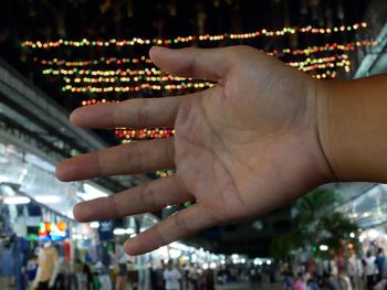 Midsection of woman with illuminated lights at night
