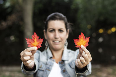 Portrait of woman holding leaves during autumn