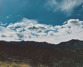 Scenic view of mountains against cloudy sky