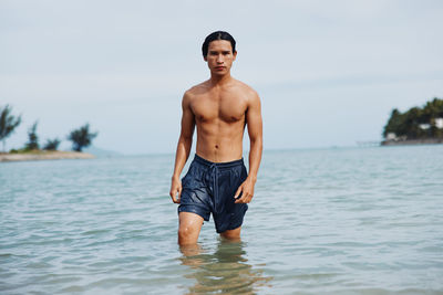 Portrait of shirtless man swimming in lake