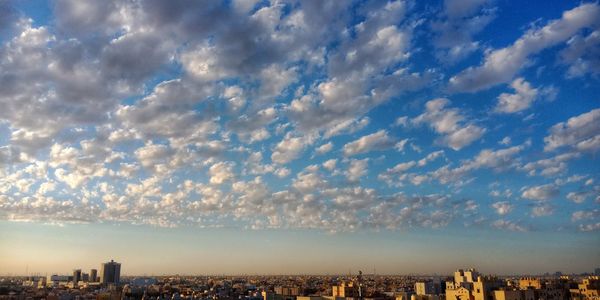 Aerial view of buildings in city against sky