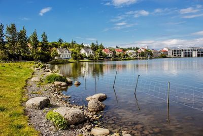Scenic view of river by trees against sky