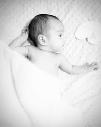 Directly above shot of cute baby girl lying on crib