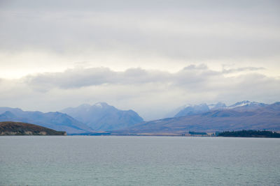 Scenic view of lake by mountains against sky