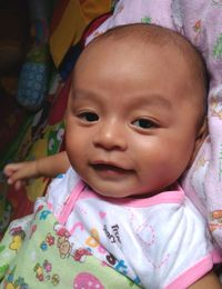 Portrait of cute baby boy lying on bed