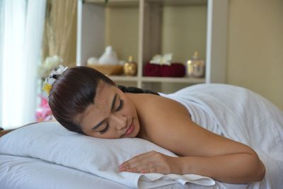 Midsection of woman sleeping in bed