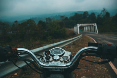 Close-up of a motorbike on field against trees