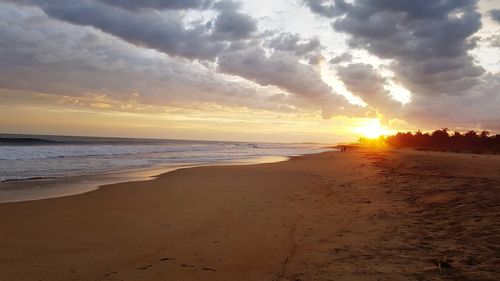 Scenic view of beach against sky during sunset