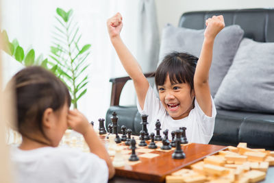 Siblings playing chess at home