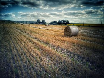 Hay bales on field against sky