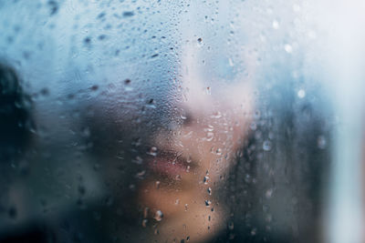 Close-up portrait of wet glass window in rainy season