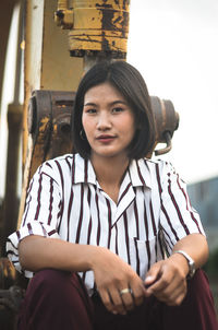 Portrait of smiling teenage girl sitting outdoors