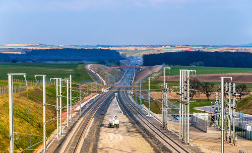 Railroad tracks by road against sky