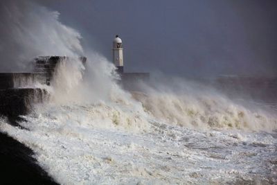 View of lighthouse by sea against sky