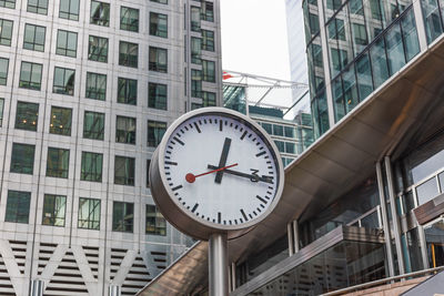 Contemporary urban clock in business district with modern glass office towers