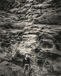 Low angle view of woman climbing on rock