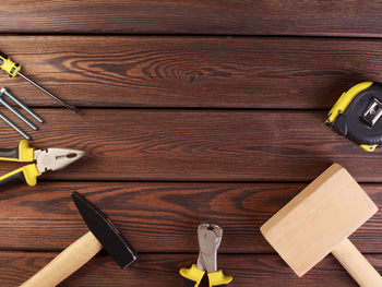 Tools worker, hammer, screwdriver, pliers on a wooden background, top view